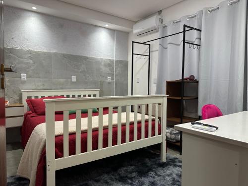 ein Schlafzimmer mit einem Kinderbett und einem roten Bett in der Unterkunft Moradas Desterro, próximo ao aeroporto 05 in Florianópolis