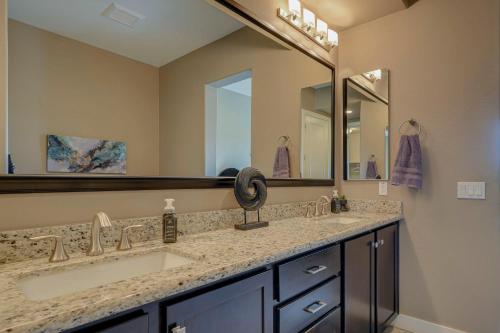 a bathroom with two sinks and a large mirror at Patios and Mountain Views at Modern Scottsdale Condo in Scottsdale