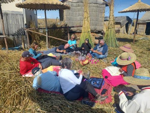 a group of people sitting in the grass at Q'OTA TAYPY LODGE in Puno