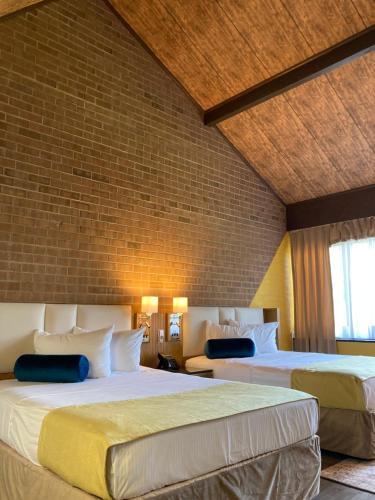a bedroom with two beds and a brick wall at Split Rock Resort in Lake Harmony