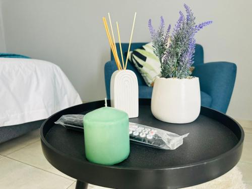 a coffee table with a green candle and three vases at Royal Mansion Lodge in Johannesburg