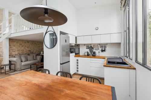 une cuisine et une salle à manger avec une table et des chaises dans l'établissement Luxury living: appartement contemporain by Weekome, à Paris