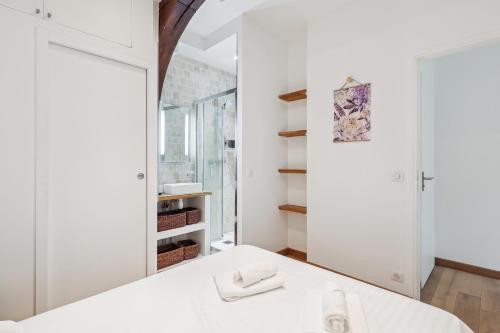 une chambre avec un lit blanc et un miroir dans l'établissement Luxury living: appartement contemporain by Weekome, à Paris