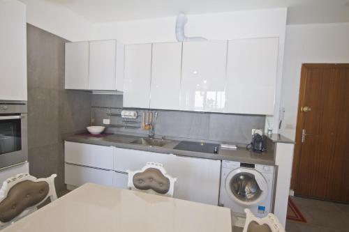 a kitchen with a table and a washing machine at Garden Floor Condo with Promenade Sea View in Nice