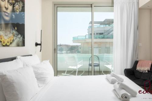 ein Schlafzimmer mit einem weißen Bett und einem großen Fenster in der Unterkunft View דירה משפחתית במיקום הטוב באילת in Eilat