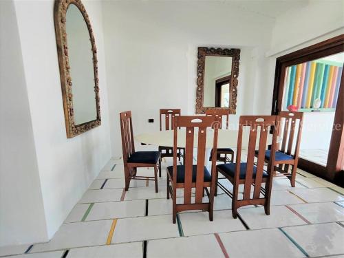 a dining room with a table and chairs and a mirror at Villa Mare Blu - Porto Rotondo in Porto Rotondo