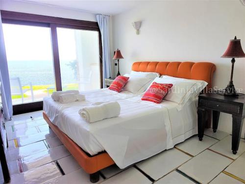 a large bed with an orange headboard in a bedroom at Villa Mare Blu - Porto Rotondo in Porto Rotondo
