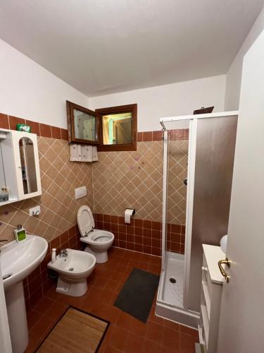 uma casa de banho com um WC, um lavatório e um chuveiro em Villetta selve em Fiumalbo