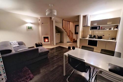 a living room with a couch and a table at Apartamenty Pod Łysicą & SPA - przy stoku, basen, jacuzzi, sauna in Krajno Pierwsze