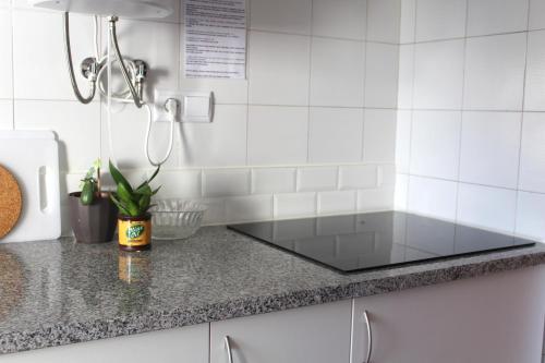 una encimera de cristal en una cocina con azulejos blancos en Guesthouse Felicidade, en Lagos
