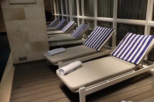 a row of chairs sitting on a balcony at Luxury Residence at Taj Cape Town - Top Corner Apartment with Balcony in Cape Town