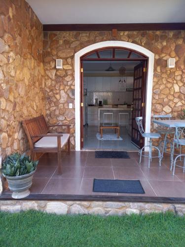 a patio with a table and chairs and a stone wall at Canoappart in Canoa Quebrada