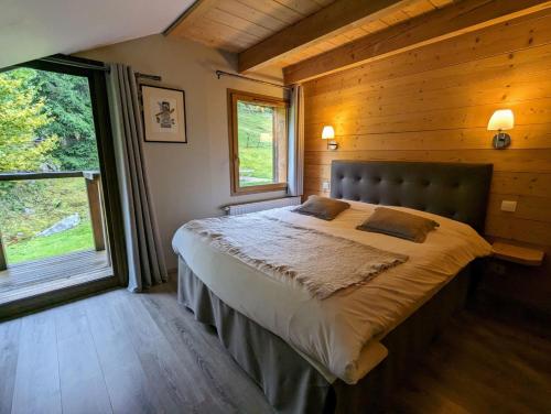 - une chambre avec un grand lit dans une cabane en bois dans l'établissement La Ferme du Douanier & Spa 5 étoiles ALL INCLUSIVE, à Ventron