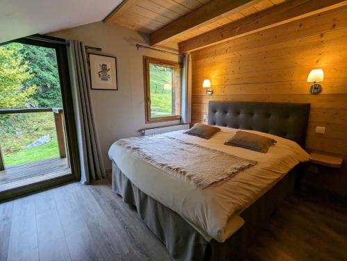 a bedroom with a large bed in a wooden cabin at La Ferme du Douanier & Spa 5 étoiles ALL INCLUSIVE in Ventron