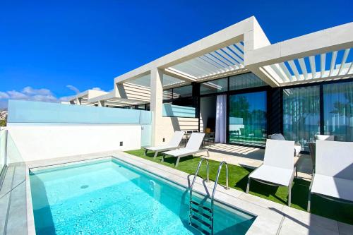 a villa with a swimming pool and a house at Resort Cordial Santa Águeda & Perchel Beach Club in La Playa de Arguineguín
