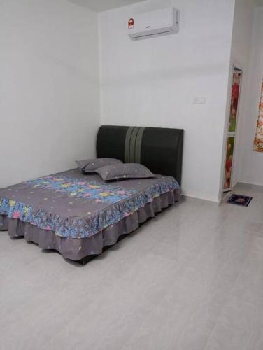 a bed in a white room with a bed sidx sidx sidx at Homestay Usrati No. 17K (untuk muslims sahaja) in Kangar