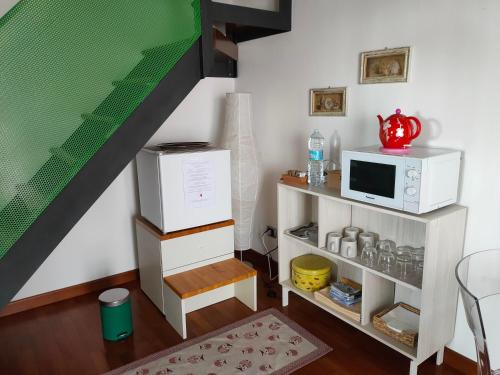 a living room with a microwave and a staircase at A casa di Rosa in Padova