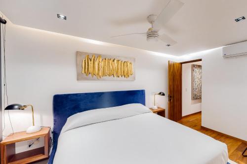 a bedroom with a large bed with a blue headboard at CUBOS El Tezal #3 in Cabo San Lucas