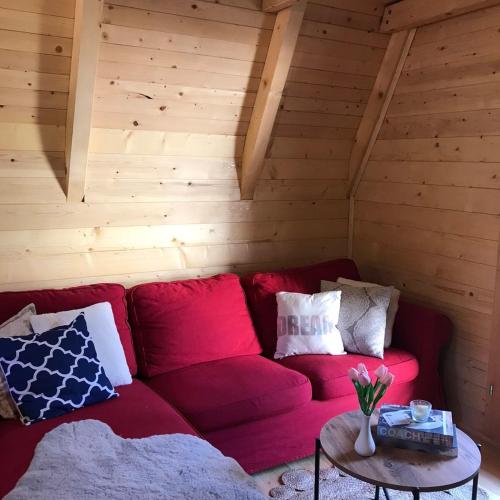 a red couch in a room with a table at Nice&cosy cabin in Cetinje