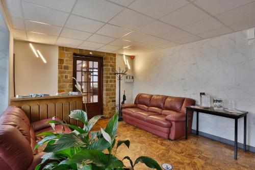 a living room with a leather couch and a table at Chez Phil in Robertville