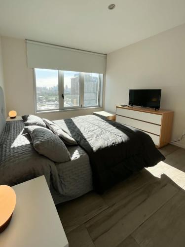 um quarto com uma cama grande e uma televisão em Departamento de un dormitorio - AMARRAS CENTER em Santa Fé