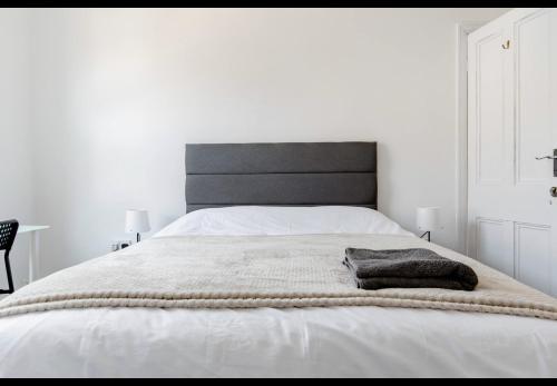 a white bedroom with a large bed with a blanket at Devondale Road, Penny Lane area in Liverpool