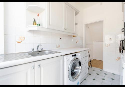 a white kitchen with a washing machine in it at Devondale Road, Penny Lane area in Liverpool