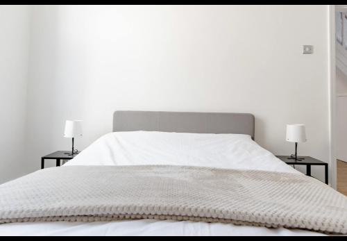 a white bedroom with a white bed with two lamps at Devondale Road, Penny Lane area in Liverpool