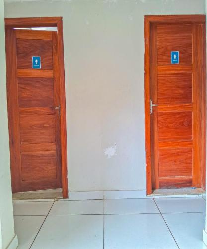 two wooden doors in the corner of a room at C&R Hostel Residencial in Salvador