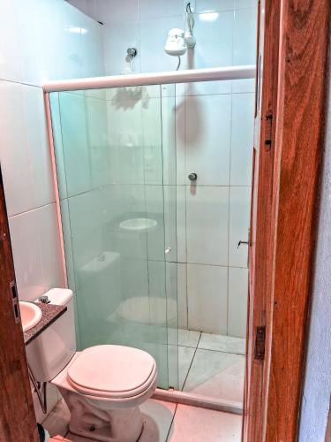 a bathroom with a toilet and a glass shower at C&R Hostel Residencial in Salvador