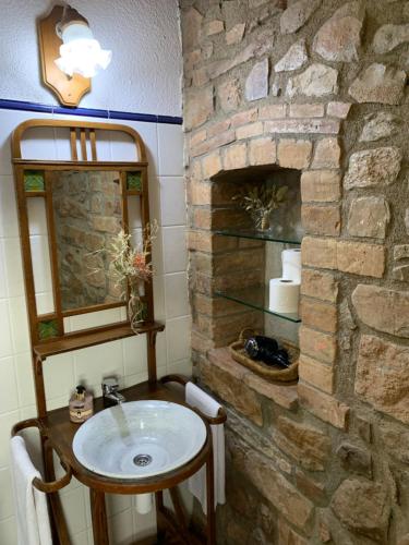 baño de piedra con lavabo y chimenea de piedra en La Pallissa Casa de Turismo Rural, en Moià