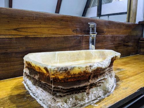 a stone sink with a water faucet on a wooden counter at Caribbean Flow in Puerto Viejo