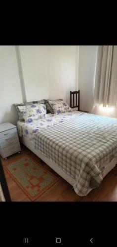 1 dormitorio con 1 cama con edredón de cuadros en Rio Vista, en Río de Janeiro