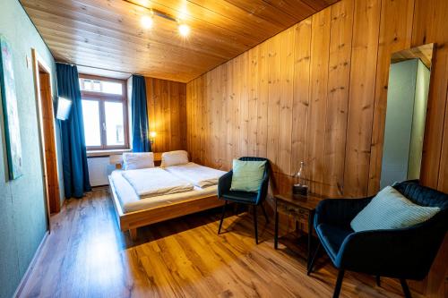 a small room with a bed and two chairs at CURUNA Pensiun-Frühstückspension in Scuol
