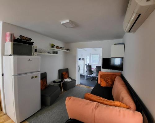 a living room with a couch and a white refrigerator at Mandrina House in Mandre