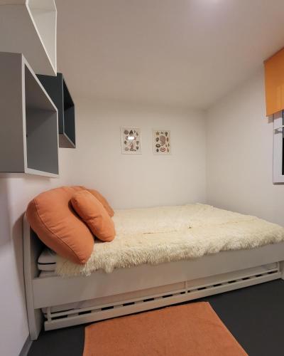 a bedroom with a bed with an orange pillow on it at Mandrina House in Mandre