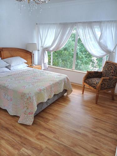 a bedroom with a bed and a chair and a window at @336 Bourke in Pretoria