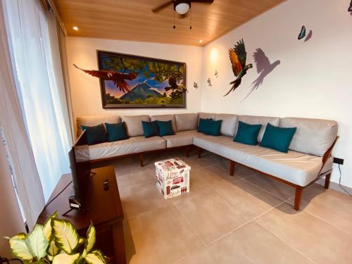 a living room with a couch and a painting on the wall at Casa Macaw in Fortuna