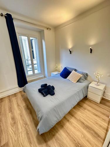 a bedroom with a large bed with blue pillows at Elegant Paris Pantin apartment - line 7 in Pantin