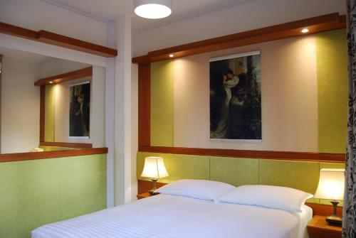 a bedroom with a bed and two pictures on the wall at La Chiocciola Apartments in Santarcangelo di Romagna