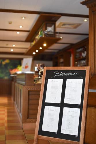 a sign in front of a restaurant with a menu at ibis Albert Pays de Somme in Albert