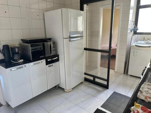 a kitchen with a white refrigerator and a microwave at Allure Morumbi in Sao Paulo