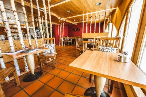 a dining room with wooden tables and chairs at CURUNA Hotel-Garni in Scuol