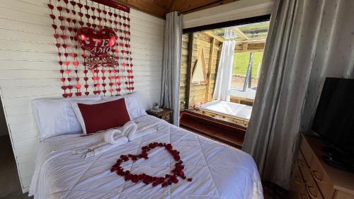 a bedroom with a bed with a heart decoration on it at Refúgio Serra da Tartaruga - Alfredo Wagner in Barracão