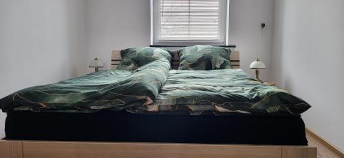 a bed in a bedroom with a blanket on it at La Casa De Roland in Wieliczka