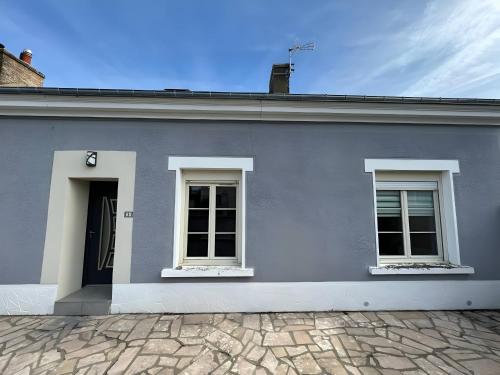 a gray house with two windows and a door at La Chaleureuse - Centre Parigné - 5p - Rêve au Mans in Parigné-lʼÉvêque