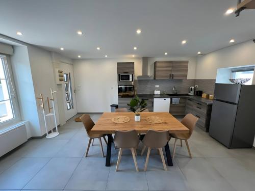 a kitchen and dining room with a wooden table and chairs at La Chaleureuse - Centre Parigné - 5p - Rêve au Mans in Parigné-lʼÉvêque