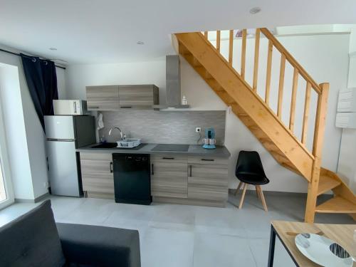 a kitchen with a sink and a refrigerator and a staircase at Lutece - Parking - Jardin - 4pers - Rêve au Mans in Parigné-lʼÉvêque