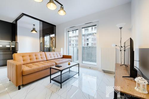 een woonkamer met een bank en een tafel bij Fuzja V by LookAp in Łódź
