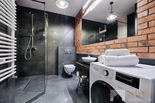 a bathroom with a shower and a toilet and a sink at Fuzja V by LookAp in Łódź